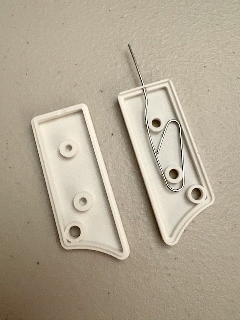 Awesome idea—exactly what I was looking for! Had a half-unfolded paperclip floating around my desk for those random device reset buttons, and I knew there had to be a print for this.
My Knipex cutters worked well for separating the pieces and trimming off the tab. I also cut a little notch out of the non-paperclip-holding side to make space for the paperclip where the pieces fit together, otherwise they wouldn't sit flush with each other.
M3 x 5mm screws worked fine. I had an M2.5 screw that seemed like it might also have fit, had that been my only choice.