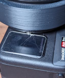 Insta360 Ace Pro Lens Mounting Plate - **Make sure the bolts are flush with the bottom ring of the mounting plate**
This is what happens if you _don't_ use countersunk bolts. These bolts I had were rounded but fairly flat. I assumed they would be fine, but the bolt touching the screen protector during twisting was enough to crack the screen protector. Thankfully in this case the actual screen is fine, but if your bolts are just a little larger or your print / applied pressure is on a little bit of an angle you could crack the real screen also.
Note: V2 of the model somewhat mitigates this by making the countersink deeper. Regardless, it's not sufficient for non-countersunk bolts. - 3d model