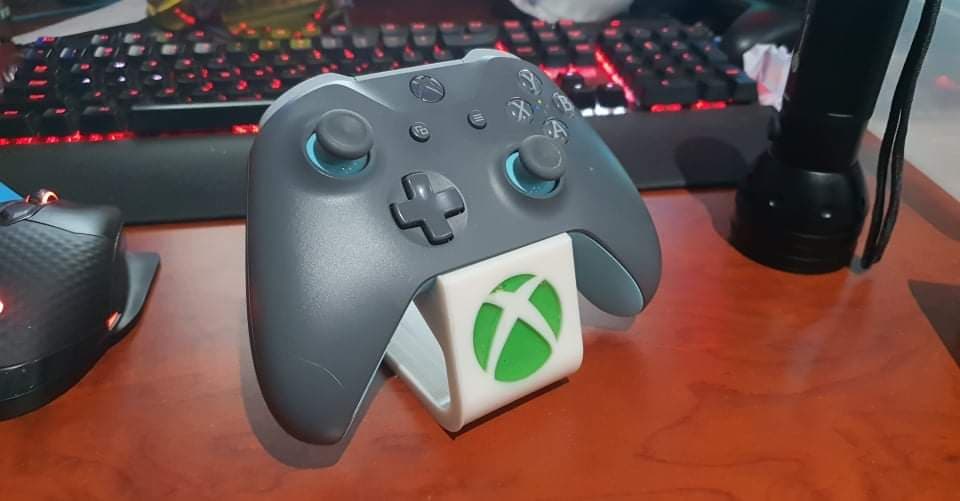 Printed in white resin with a hand injected transparent green inlay for the logo.
Holds the controller beautifully.