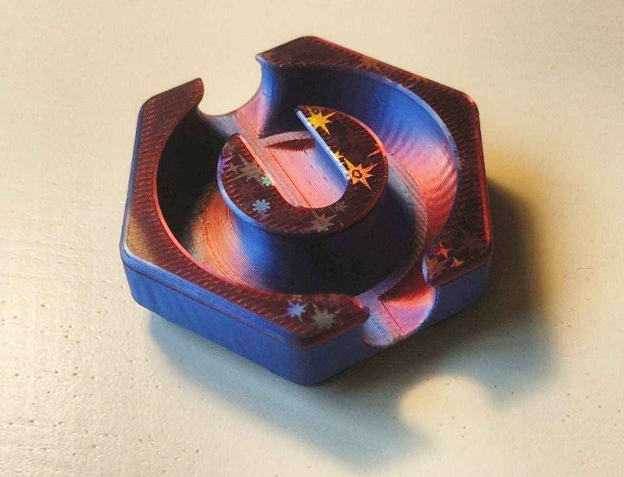 PLA Silk Dual Color (bambulab) with holographic effect on both sides. I cut the model to get bottom and top surface onto the buildplate. Added some pins to perfectly align them after printing. The print also uses variable layer heights to get the smoothest possible curves.