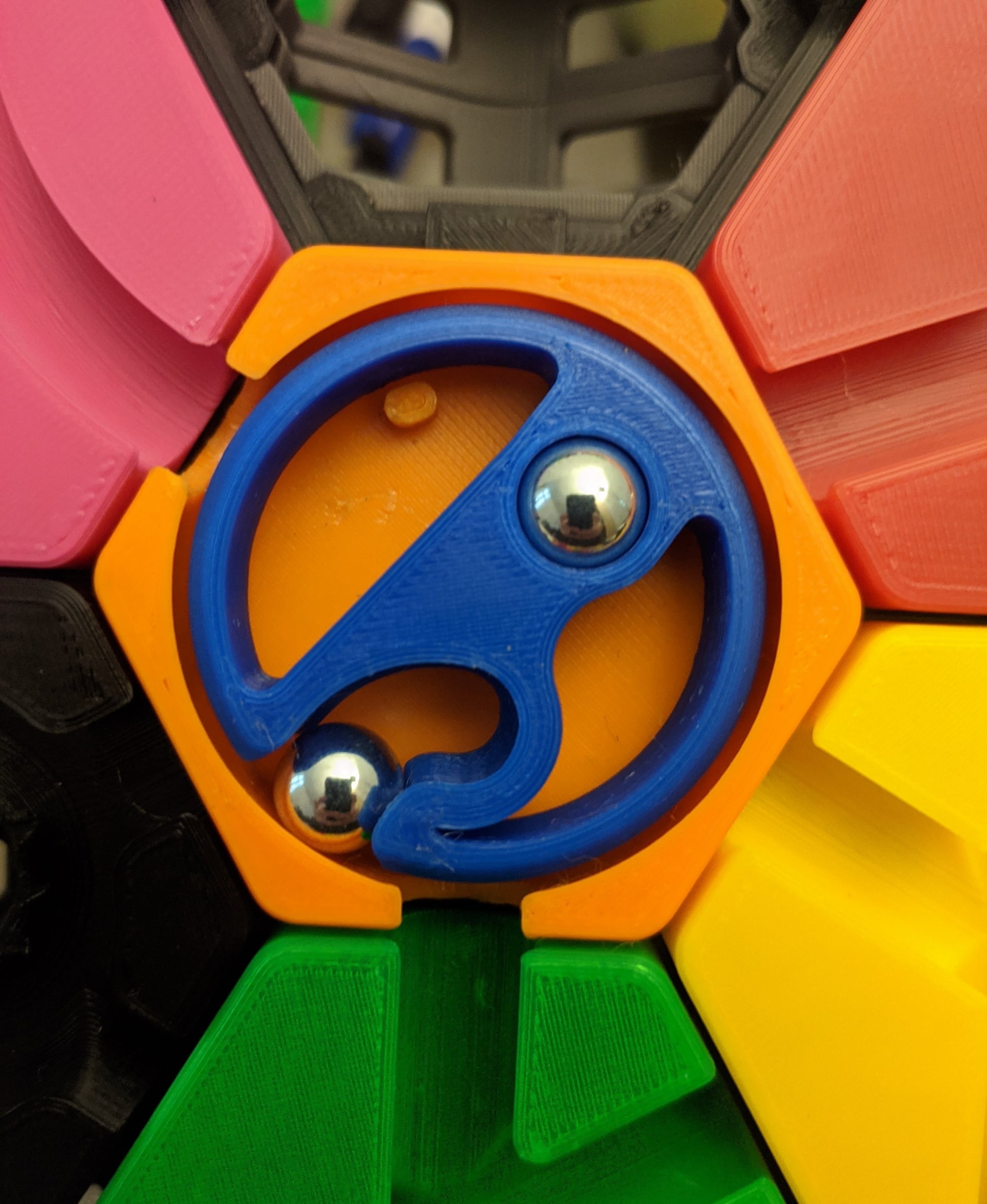 Doesn't work for me. The tile spins perfectly without any friction.
Yet 99% of the time it only releases one ball properly. The second ball starts to roll out but is then caught by the counterweight, stuck near the bottom, as shown in the picture.
Using PETG and 10mm steel balls.